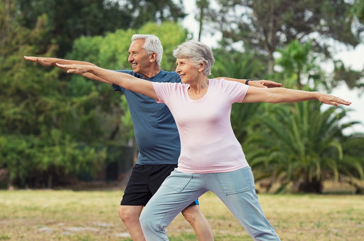 Old man and woman doing stretching exercise to help prevent common fall risks for seniors