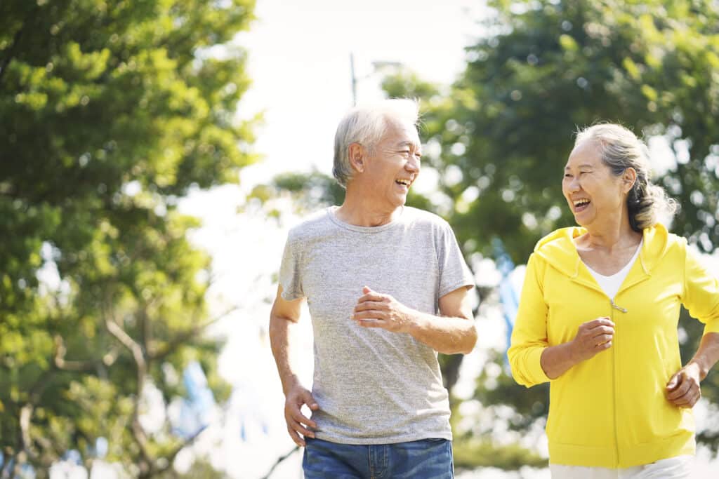 happy asian old couple jogging running outdoors in park