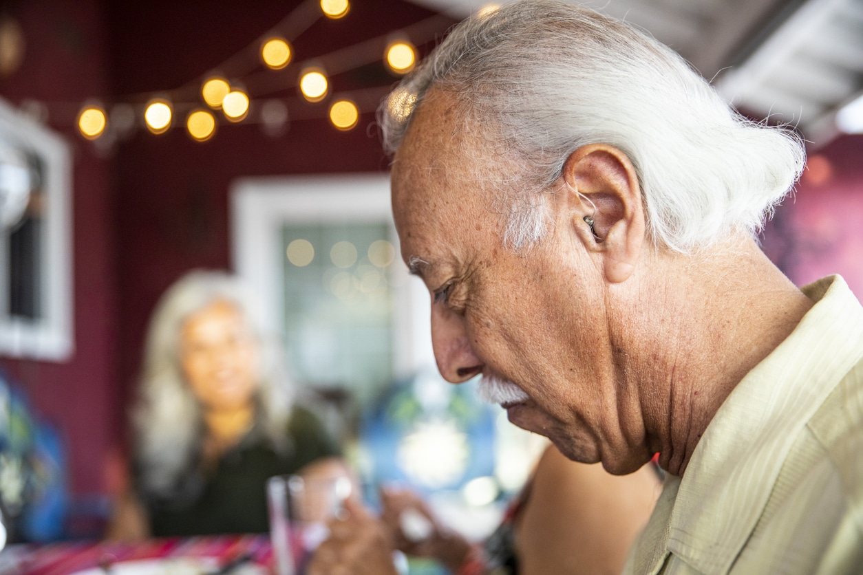 Senior man with hearing aid at dinner