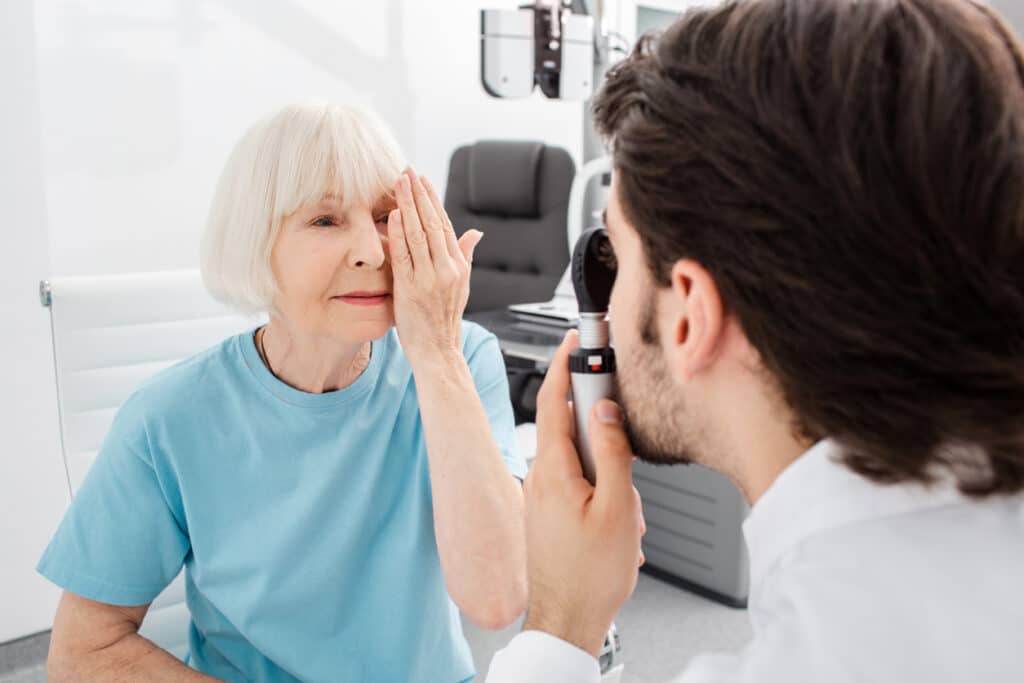 Senior woman patient checking vision in optician's office. Eye exam and vision diagnostic