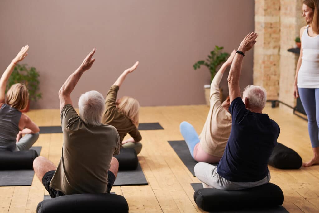 senior stretching in yoga class