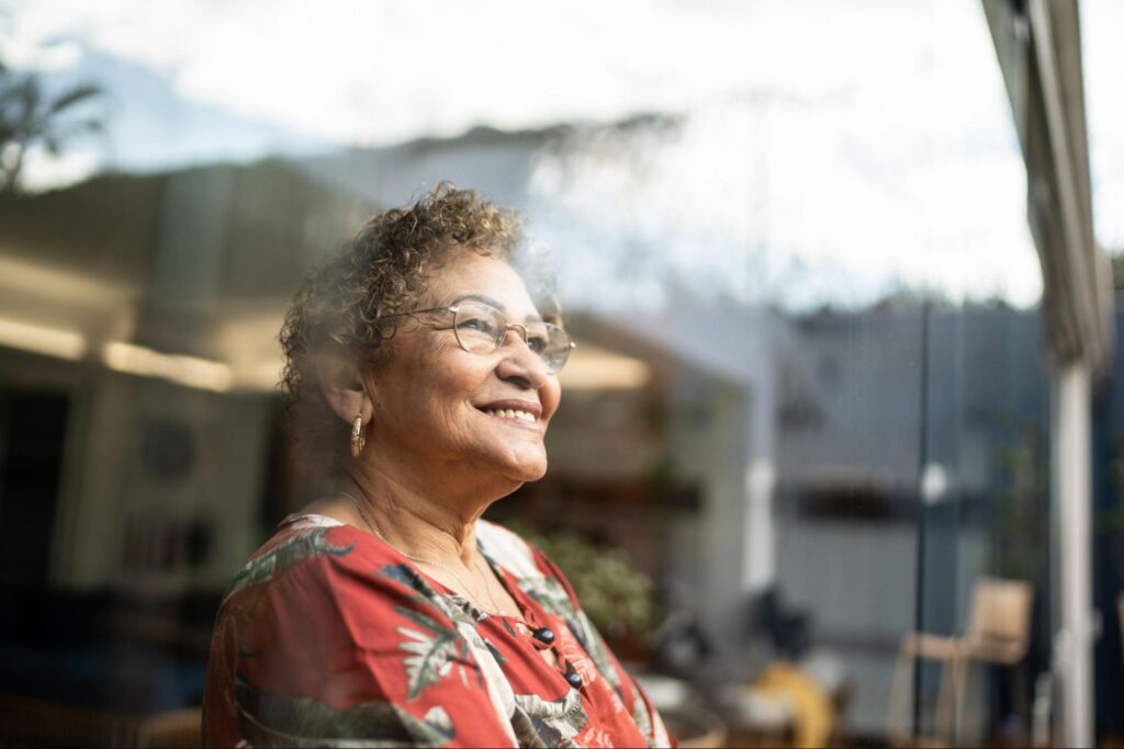 happy-elderly-woman-looking-out-window